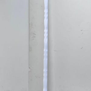 May include: A white walking cane with a curved handle and a textured shaft. The cane has a silver metal band near the handle and a black rubber tip. The cane is approximately 36 inches in length.