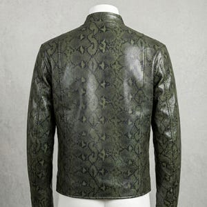 Peut inclure: Veste verte &agrave; motif peau de serpent avec col montant. La vue arri&egrave;re met en valeur le motif en &eacute;cailles vert et noir. La veste, probablement en cuir ou mati&egrave;re similaire, est un v&ecirc;tement d'ext&eacute;rieur &eacute;l&eacute;gant.