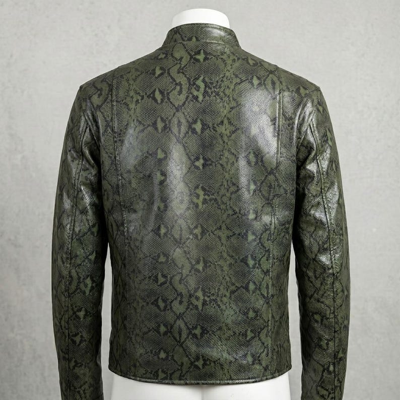 Peut inclure: Veste verte &agrave; motif peau de serpent avec col montant. La vue arri&egrave;re met en valeur le motif en &eacute;cailles vert et noir. La veste, probablement en cuir ou mati&egrave;re similaire, est un v&ecirc;tement d'ext&eacute;rieur &eacute;l&eacute;gant.