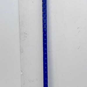 May include: A clear acrylic walking cane with a curved handle and a silver-colored metal collar. The shaft is a vibrant blue with a series of evenly spaced, circular indentations. The cane's tip is black.