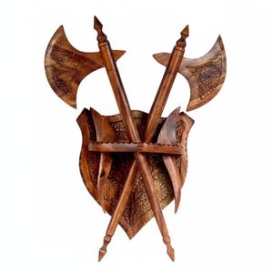 Op de afbeelding: Houten wanddecoratie met twee gekruiste bijlen en een schild. De bijlen en het schild zijn ingewikkeld gesneden met bloemmotieven. De bijlen hebben puntige punten en gebogen bladen. Het schild heeft een decoratieve rand en een centrale steun voor de bijlen. Het hout heeft een warme, bruine tint.