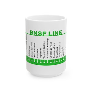 May include: A white ceramic mug featuring a green graphic design of the BNSF Line train route. The text BNSF LINE is printed in green at the top, followed by a list of station names including Fairview, Westmont, Hinsdale, and others.