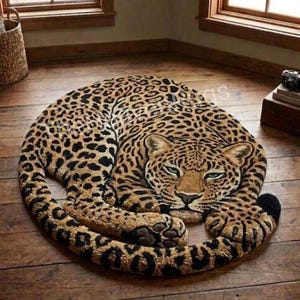 Könnte beinhalten: Ein getufteter Teppich in Form eines zusammengerollten Leoparden mit einem beigen, braunen und schwarzen gefleckten Fell. Der Leopard ist in einer ruhenden Position dargestellt, mit dem Kopf nach vorne und einer langen Schwanzumrandung.