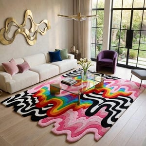 May include: A rectangular area rug featuring a vibrant, multi-colored wavy pattern with layers of pink, red, orange, yellow, green, and blue, contrasted by bold black and white undulating lines that extend into irregular, organic shapes at the edges.