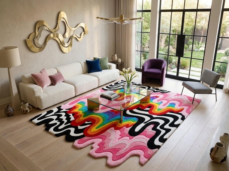 May include: A rectangular area rug featuring a vibrant, multi-colored wavy pattern with layers of pink, red, orange, yellow, green, and blue, contrasted by bold black and white undulating lines that extend into irregular, organic shapes at the edges.