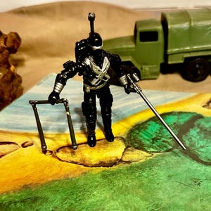 May include: A set of three ceramic mugs with a speckled, matte finish. The mugs are in shades of blue, green, and white. Each mug has a rounded handle and a simple, modern design. The mugs are stacked on top of each other.