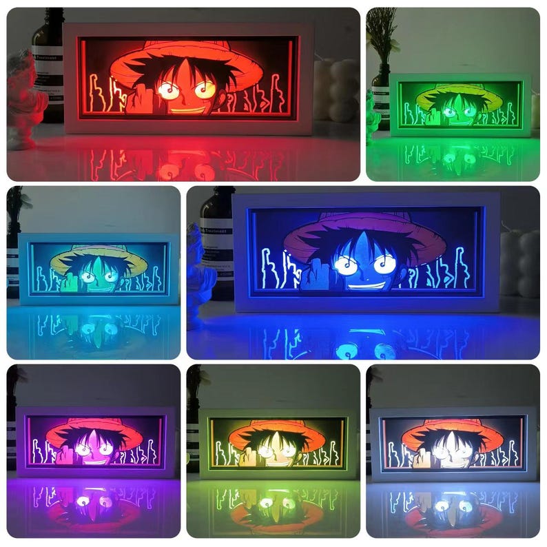 Pu&ograve; includere: Una scatola luminosa a LED rettangolare con un personaggio dei cartoni animati con un cappello di paglia. Il volto del personaggio &egrave; illuminato e la scatola luminosa ha una cornice bianca. La scatola luminosa &egrave; mostrata con luci di diversi colori, tra cui rosso, verde e blu.