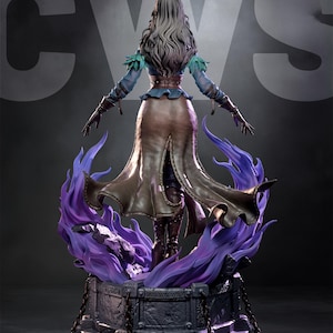 May include: A detailed statue of a woman with long gray hair, wearing a blue top, brown skirt, and boots. She stands on a stone base with purple flames. The statue has a dramatic pose with arms outstretched.