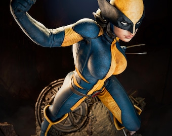 May include: A detailed figurine of a female superhero in a dynamic pose, wearing a blue and yellow costume with a mask. The figure has claws extended and is set against a dark background. The base features a circular emblem and a helmet.