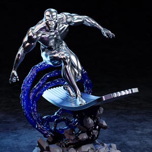 Puede incluir: Estatua cromada de una figura surfeando sobre una tabla plateada, con un efecto de ola azul. La figura es musculosa y tiene una superficie reflectante. La base es gris oscuro con detalles negros.