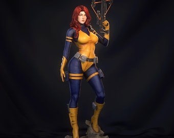 May include: A figurine of a female character in a yellow and blue bodysuit, holding a crossbow. The character has red hair and is standing on a rocky base. The figure is detailed and appears to be a collectible item.