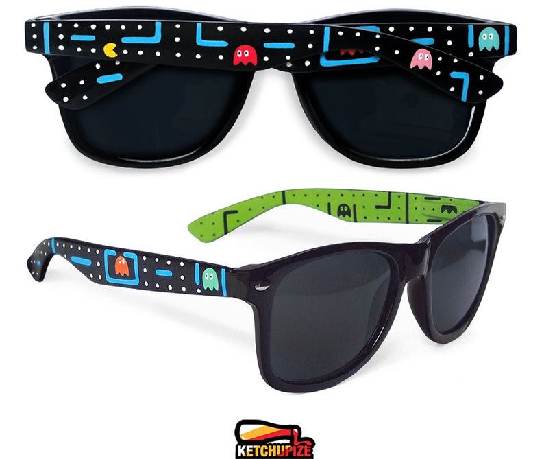 Picture of black sunglasses, hand-painted with an Arcade video game inspired design, including yellow, red, pink, orange and blue monsters and ghosts, white dots and blue lines.