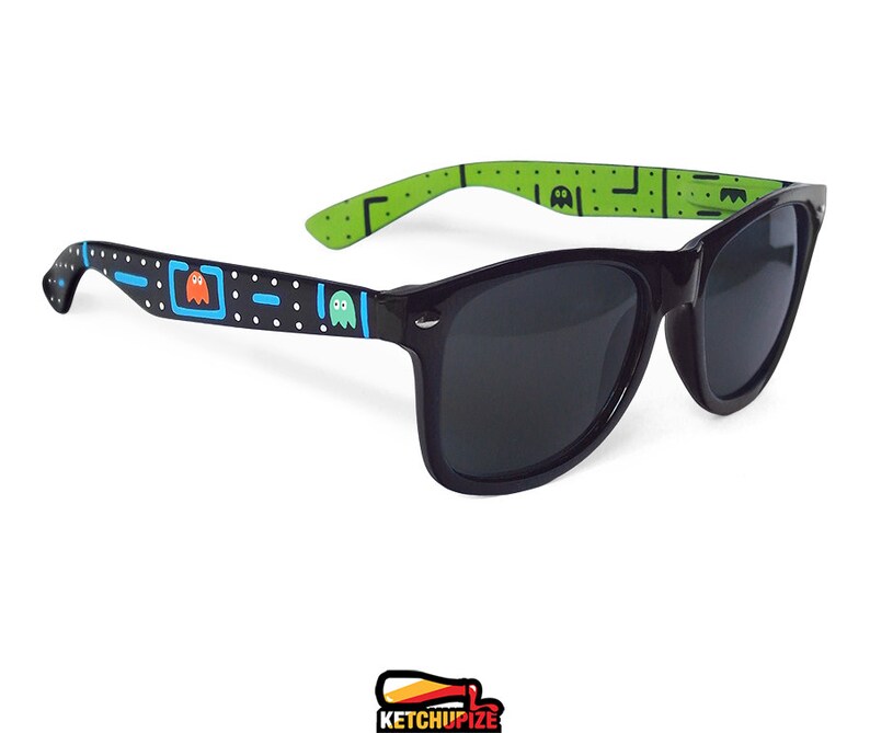 Picture of black sunglasses, hand-painted with an Arcade video game inspired design, including yellow, red, pink, orange and blue monsters and ghosts, white dots and blue lines.