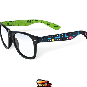 Picture of black clear lens glasses, hand-painted with an Arcade video game inspired design, including yellow, red, pink, orange and blue monsters and ghosts, white dots and blue lines.