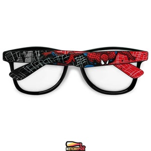 Picture of black prescription glasses, hand-painted with a Spiderman comic theme design, showing Spiderman against spider web and the city skyline, in red, blue and black colors.