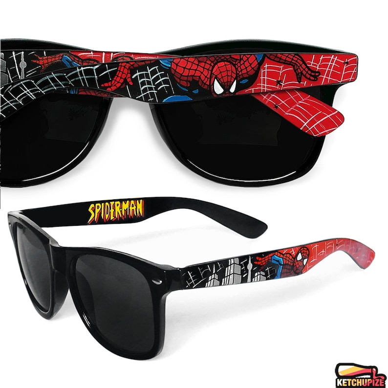 Picture of black sunglasses, hand-painted with a Spiderman comic theme design, showing Spiderman against spider web and the city skyline, in red, blue and black colors.