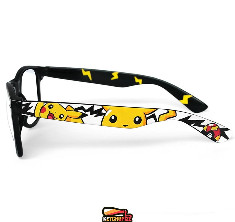 Picture of black clear lens glasses, hand-painted with a Pokemon design, including yellow Pikachu, black bolts and red and white Pokeballs on a white background, in white, black, yellow and red colors.