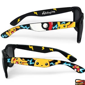 Picture of black sunglasses, hand-painted with a Pokemon design, including yellow Pikachu, blue and white bolts and red and white Pokeballs on a black background, in white, black, yellow, red and blue colors.