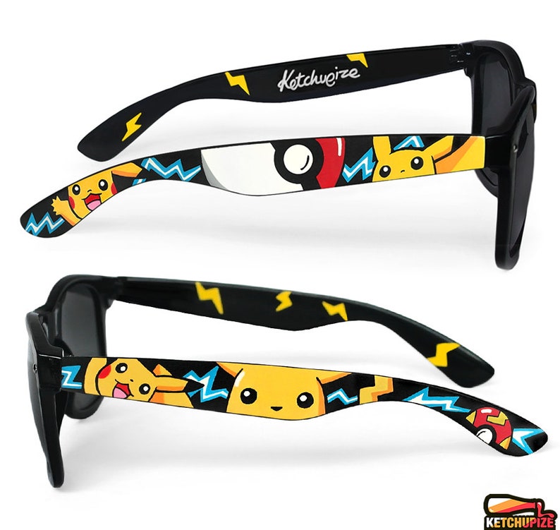 Picture of black sunglasses, hand-painted with a Pokemon design, including yellow Pikachu, blue and white bolts and red and white Pokeballs on a black background, in white, black, yellow, red and blue colors.