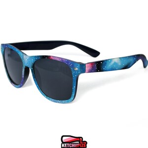 Picture of black sunglasses, hand-painted with a galaxy design in blue, purple and pink colors.