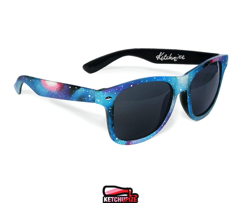 Picture of black sunglasses, hand-painted with a galaxy design in blue, purple and pink colors.