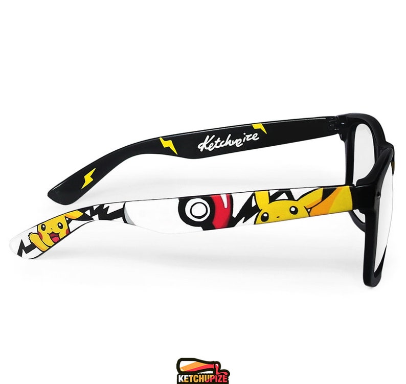 Picture of black clear lens glasses, hand-painted with a Pokemon design, including yellow Pikachu, black bolts and red and white Pokeballs on a white background, in white, black, yellow and red colors.