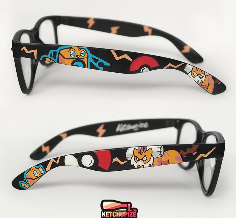 Picture of black clear lens glasses, hand-painted with a Pokémon design, including Landorus-Therian and Rotom-Wash and red and white Pokeballs on a black background, in orange, yellow, blue and red colors.