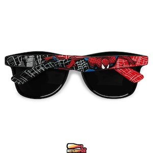 Picture of black sunglasses, hand-painted with a Spiderman comic theme design, showing Spiderman against spider web and the city skyline, in red, blue and black colors.