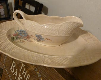 This vintage ceramic gravy boat and  underplate appear to be a Homer Lau