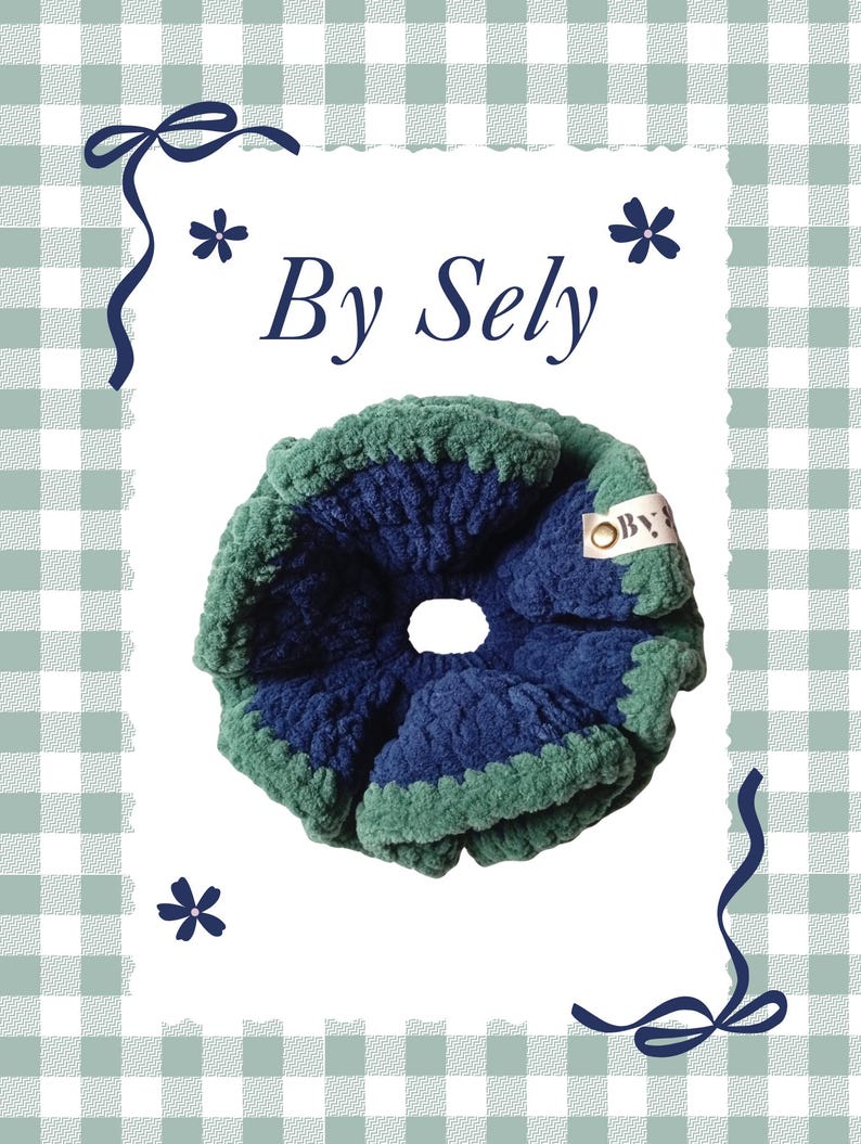 以下が含まれることがあります： 青と緑の色合いの手作りのシュシュで、白い背景に「By Sely」の文字が入っています。 シュシュは柔らかく質感のある素材で作られており、花柄とリボンのアクセントが付いた装飾的なボーダーで囲まれています。