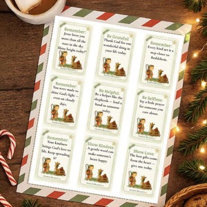 May include: A sheet of Christmas cards with inspirational messages and illustrations of a shepherd and animals. The cards have a green and red border and are on a wooden surface.