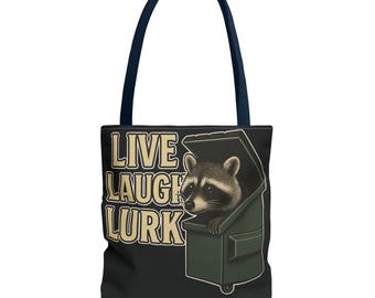May include: Black tote bag with navy handles featuring a raccoon peeking out of a green dumpster. The text "LIVE LAUGH LURK" is printed in a vintage style font on the front of the bag.