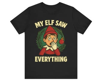 May include: Black t-shirt with the text "MY ELF SAW EVERYTHING". The graphic features a surprised elf with a red hat and collar, surrounded by a green wreath and a red ornament. The design has a vintage, cartoon style.