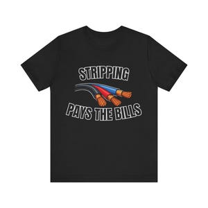 Op de afbeelding: Zwart t-shirt met de tekst "STRIPPING PAYS THE BILLS" in het wit. De afbeelding toont drie gekleurde draden: zwart, rood en blauw, met blootliggende koperen uiteinden. Een humoristisch ontwerp voor elektriciens.