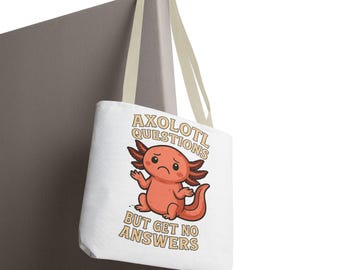 May include: White tote bag with a cartoon axolotl and the text "AXOLOTL QUESTIONS BUT GET NO ANSWERS". The axolotl is orange and has a sad expression. The bag has cream-coloured straps.