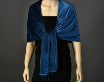 May include: A teal blue velvet shawl draped over a mannequin. The shawl is tied at the neck and the ends hang down the front of the mannequin.