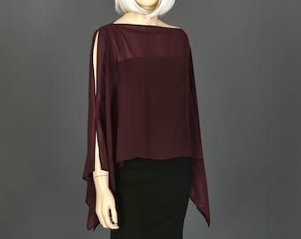 May include: A maroon long-sleeved top with a boat neck and side slits. The top is made of a lightweight, flowing fabric.