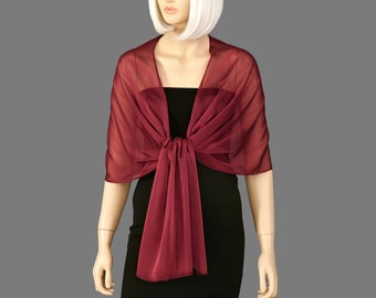 May include: A burgundy chiffon shawl with a sheer texture. The shawl is tied around the neck and drapes down the front of the body.