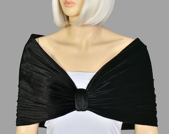 May include: A black velvet shawl with a bow in the front. The shawl is draped over a mannequin's shoulders.