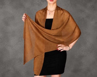 May include: A solid brown rectangular shawl made of a lightweight, semi-sheer fabric. The shawl is draped over the shoulders and across the front of the torso, showcasing its smooth texture and consistent earthy brown colour throughout the material.