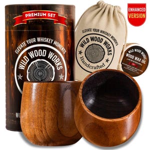May include: A wooden whiskey set featuring two round wooden glasses, a cylindrical container, a drawstring bag, and a small tin of wax oil. The set is branded with the text "Wild Wood Works" and "Elevate Your Whiskey Moments."