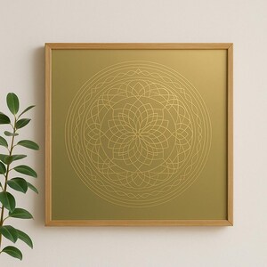 Könnte beinhalten: Quadratische gerahmte Kunst mit einem goldenen Mandala-Design auf goldenem Hintergrund. Das Mandala ist ein detailliertes, symmetrisches Muster mit floralen und geometrischen Elementen. Der Rahmen besteht aus hellbraunem Holz.