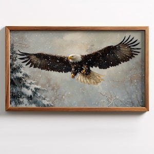 May include: A framed painting of a bald eagle in flight, wings spread wide. The eagle has brown and white feathers, a yellow beak, and a white head. The background shows a snowy forest scene.