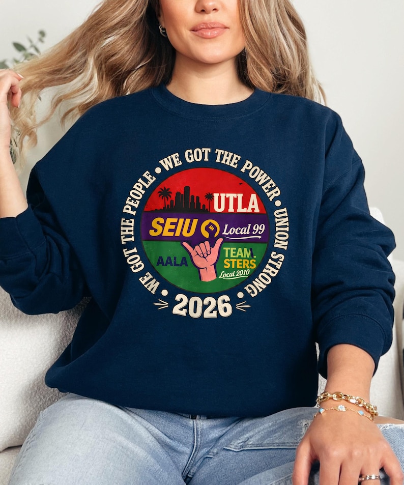 May include: Navy blue sweatshirt with a circular graphic. The graphic includes text that reads "WE GOT THE POWER" and "UNION STRONG". The graphic also features the text "UTLA", "SEIU Local 99", "TEAMSTERS Local 2010", and "2026".