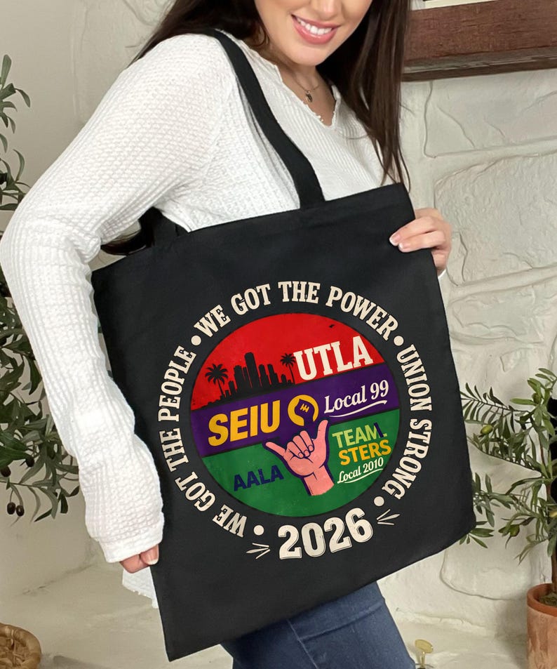 May include: Black tote bag with a circular graphic featuring the text "WE GOT THE POWER" and "UNION STRONG." The graphic includes the text "UTLA," "SEIU Local 99," "TEAMSTERS Local 2010," and "2026." A hand gesture is also visible.