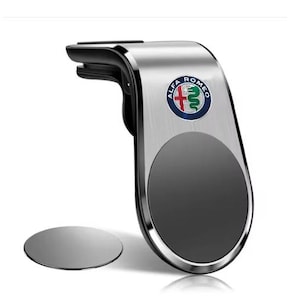 Op de afbeelding: Zilver-zwarte autotelefoonhouder met het Alfa Romeo-logo. De houder heeft een magnetisch oppervlak en een aparte magnetische schijf. Ontworpen om aan een ventilatierooster van een auto te bevestigen.