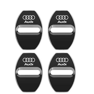Könnte beinhalten: Satz von vier schwarzen Türschlossabdeckungen für Autos mit silberner Umrandung. Jede Abdeckung zeigt das Audi-Logo und den Markennamen in Weiß. Die Abdeckungen haben eine ovale Form mit einer rechteckigen Öffnung in der Mitte.