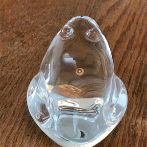 May include: A white ceramic mug with a black handle and the text "But First, Coffee" in a bold, black font. The mug is set against a neutral background, highlighting its simple design.