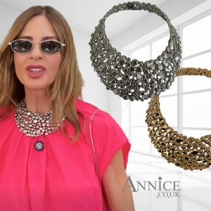 May include: A statement necklace featuring a cluster of metallic, pebble-like beads in both silver and gold tones. The design is a wide, crescent-shaped collar that sits high on the neck. The text Annice.co.uk is visible in the bottom right corner.