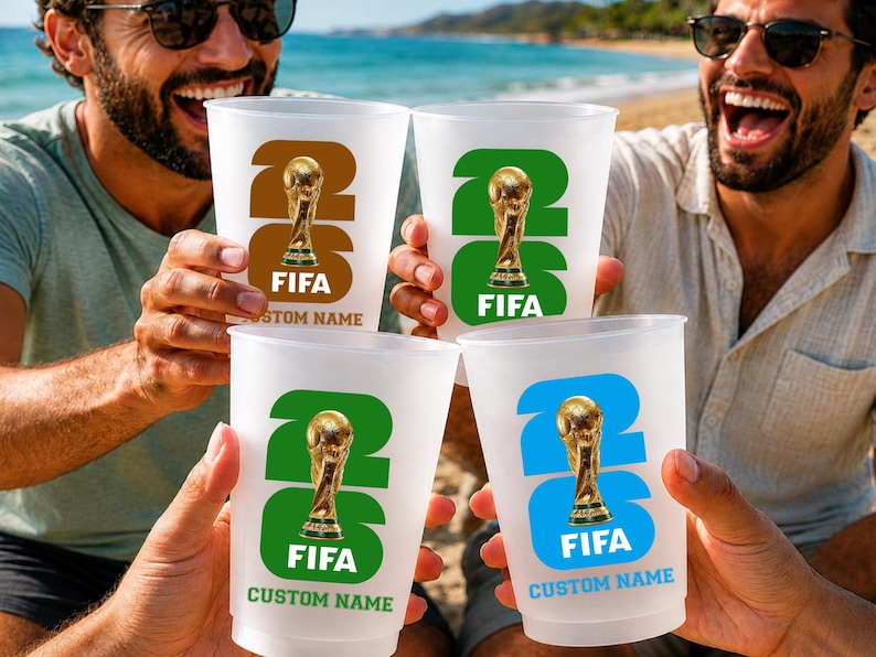 May include: Four clear plastic cups with a FIFA World Cup design. Each cup features the number 26, a gold trophy, the word FIFA, and the text "CUSTOM NAME" in a different colour: brown, green, green, and blue.